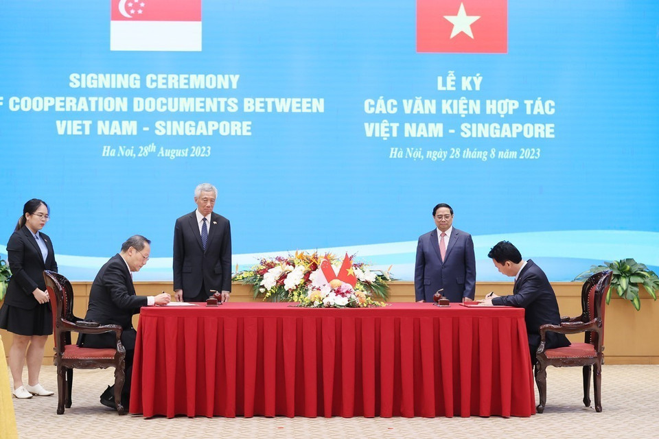 Thủ tướng Phạm Minh Chính và Thủ tướng Singapore Lý Hiển Long chứng kiến ký Ý định thư giữa Bộ Tài nguyên và Môi trường Việt Nam và Bộ Công Thương Singapore về việc tiếp tục thực hiện Bản ghi nhớ hợp tác theo Điều 6 Thỏa thuận Paris. (Ảnh: Dương Giang/TTXVN)