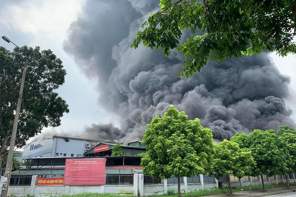  Một dãy nhà xưởng lợp tôn của công ty này bị lửa bao phủ, khói bốc ra cuồn cuộn. Nhiều xe cứu hỏa đang được huy động tới hiện trường.(Ảnh: Sơn Bách/Vietnam+)