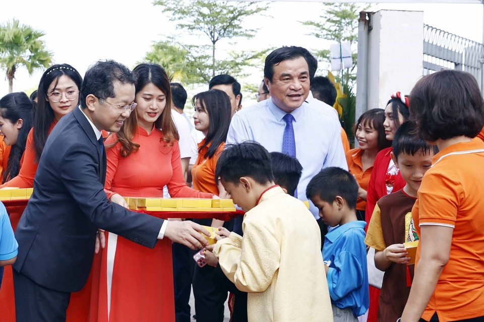 Các đại biểu phát quà cho học sinh trường tiểu học, trung học cơ sở và trung học phổ thông Hy Vọng tại Ngày hội tới trường. (Ảnh: Thống Nhất/TTXVN)