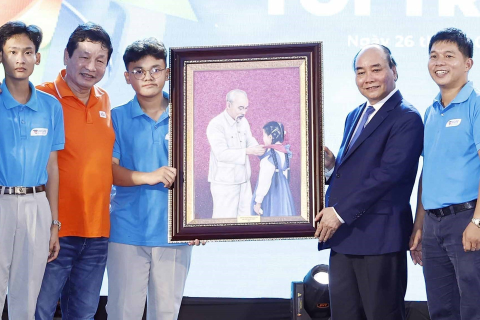 Chủ tịch nước Nguyễn Xuân Phúc tặng quà lưu niệm cho trường tiểu học, trung học cơ sở và trung học phổ thông Hy Vọng.(Ảnh: Thống Nhất/TTXVN)