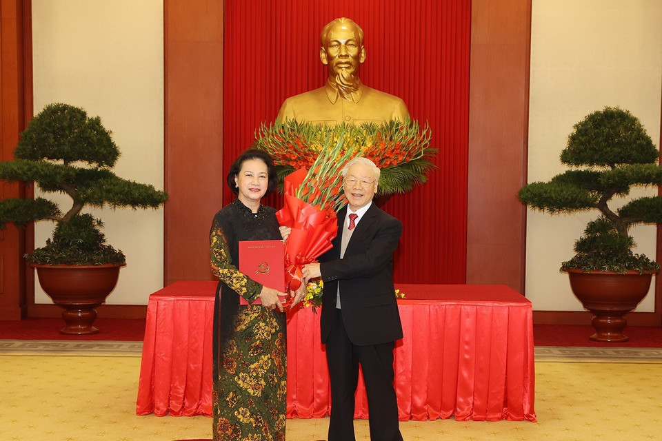 Tổng Bí thư Nguyễn Phú Trọng trao Quyết định và tặng hoa đồng chí Nguyễn Thị Kim Ngân, nguyên Ủy viên Bộ Chính trị, nguyên Bí thư Đảng đoàn Quốc hội, nguyên Chủ tịch Quốc hội. (Ảnh: Trí Dũng/TTXVN)