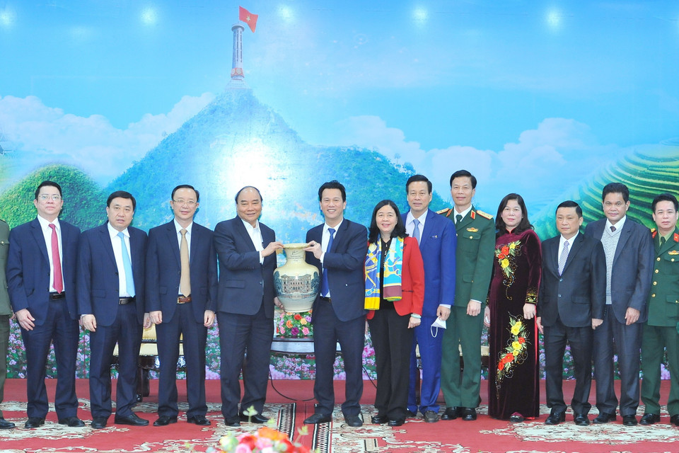 Chủ tịch nước Nguyễn Xuân Phúc đón nhận quà kỷ niệm do đồng chí Đặng Quốc Khánh, Ủy viên Ban chấp hành Trung ương Đảng, Bí thư tỉnh ủy Hà Giang trao tặng. (Ảnh: Minh Đức/TTXVN)