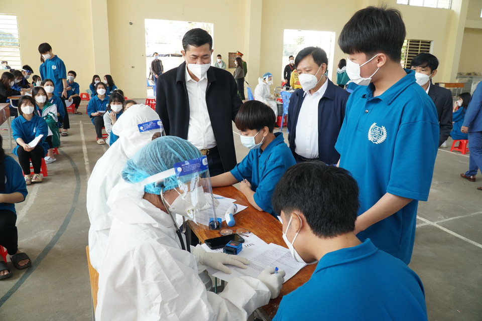 Lãnh đạo Sở Giáo dục và Đào tạo thăm hỏi, động viên học sinh tiêm vaccine tại điểm tiêm trường THPT Chuyên Phan Bội Châu, thành phố Vinh. (Ảnh: Bích Huệ/TTXVN)