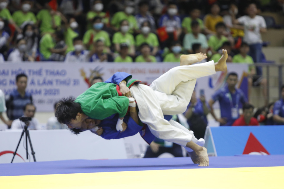 Pha đánh của vận động viên Võ Phạm Hoàng Ân (áo xanh lá cây) và vận động viên Llamas Al Rolan Sorne (Philippines). (Ảnh: Trần Việt/TTXVN)