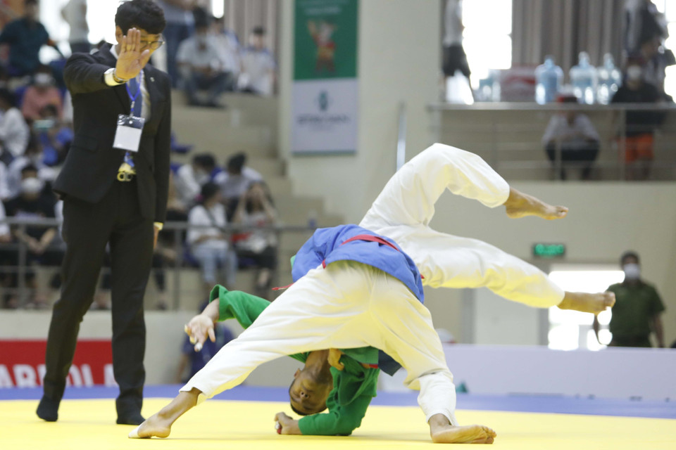 Vận động viên Lê Đức Đồng (xanh dương) với một pha đánh quyết định với vận động viên Saengkaew Natchanon (Thái Lan). (Ảnh: Trần Việt/TTXVN)