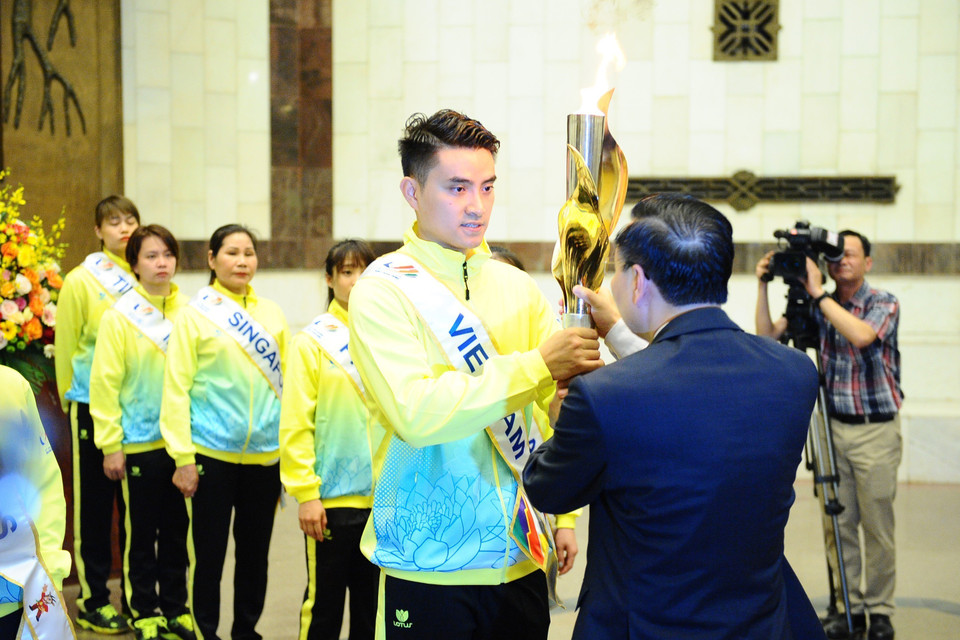 Chủ tịch thành phố Hà Nội Chu Ngọc Anh trao ngọn lửa cho vận động viên tiêu biểu. (Ảnh: Minh Đức/TTXVN)