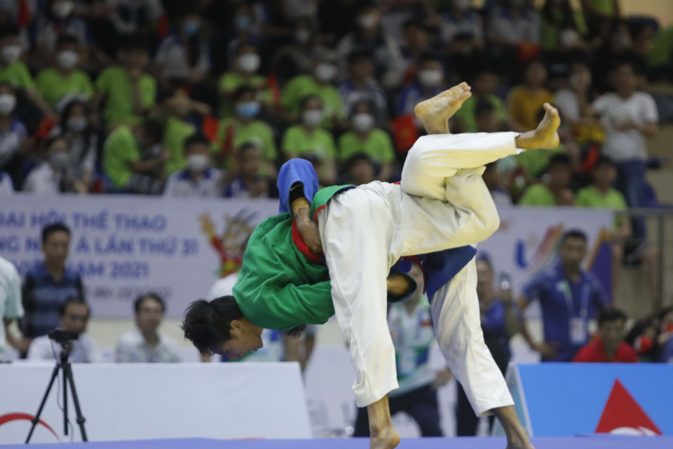 Pha đánh của vận động viên Võ Phạm Hoàng Ân (áo xanh lá cây) và vận động viên Llamas Al Rolan Sorne (Philippines). (Ảnh: Trần Việt/TTXVN)