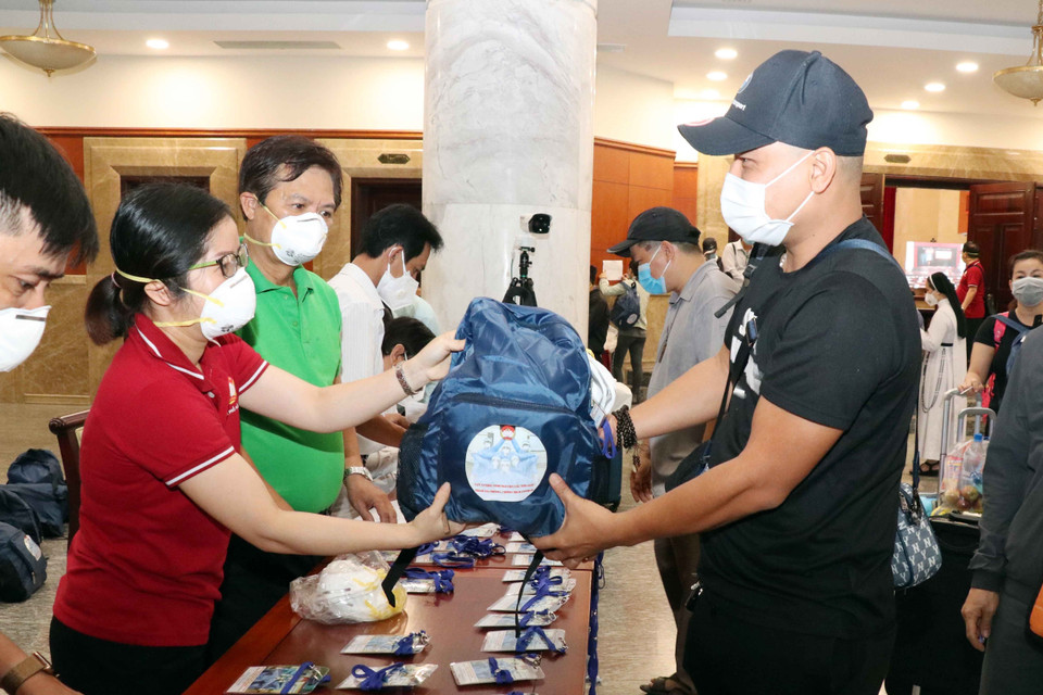 Cán bộ Mặt trận Tổ quốc Việt Nam Thành phố Hồ Chí Minh trao ba lô , vật dụng cá nhân cho các tình nguyện viên tôn giáo tham gia phòng, chống dịch COVID-19. (Ảnh: Xuân Khu/TTXVN)