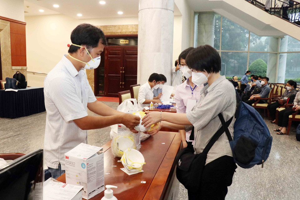 Các tình nguyện viên nhận khẩu trang N95 đảm bảo chống lây nhiễm trong môi trường tại các bệnh viện điều trị COVID-19. (Ảnh: Xuân Khu/TTXVN)