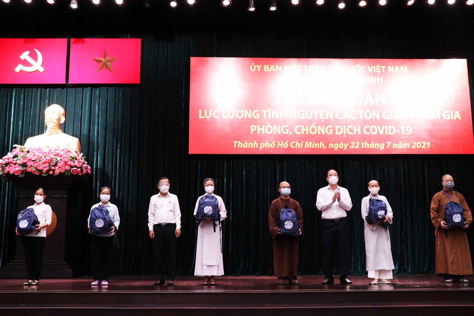 Sáng 22/7/2021, tại Hội trường Thành ủy Thành phố Hồ Chí Minh, Ủy ban Mặt trận Tổ quốc Việt Nam Thành phố Hồ Chí Minh trang trọng tổ chức Lễ xuất quân lực lượng tình nguyện tôn giáo đợt đầu tiên tham gia hỗ trợ các bệnh viện dã chiến, bệnh viện hồi sức COVID-19 trên địa bàn Thành phố. Trong ảnh: Lãnh đạo Thành phố trao tượng trương ba lô, vật dụng cá nhân cho đại diện các tình nguyện viên tôn giáo. (Ảnh: Xuân Khu/TTXVN)