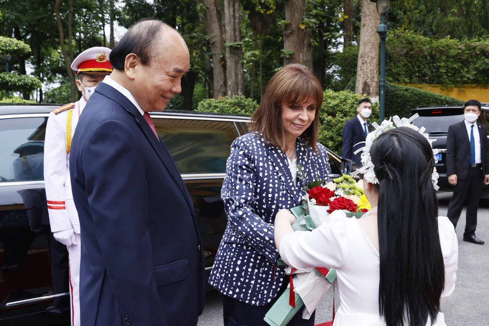 Thiếu nhi Hà Nội tặng hoa Tổng thống Hy Lạp Katerina Sakellaropoulou tại lễ đón. (Ảnh: Thống Nhất/TTXVN)