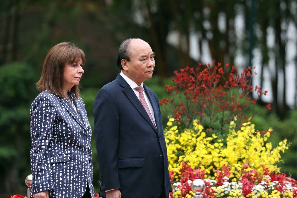 Chủ tịch nước Nguyễn Xuân Phúc và Tổng thống Hy Lạp Katerina Sakellaropoulou nghe quân nhạc cử Quốc thiều hai nước. (Ảnh: Thống Nhất/TTXVN)