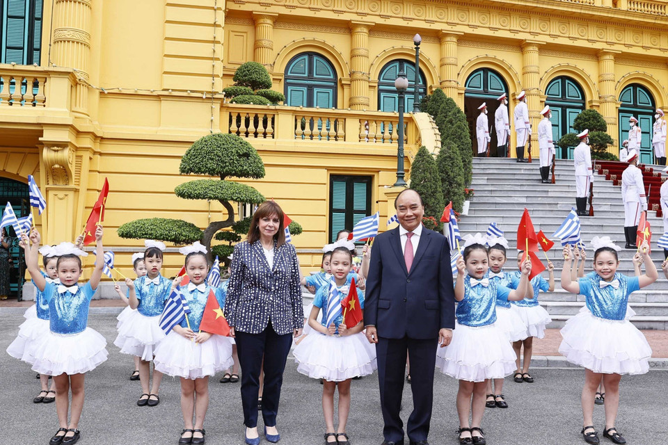 Chủ tịch nước Nguyễn Xuân Phúc và Tổng thống Hy Lạp Katerina Sakellaropoulou với thiếu nhi Hà Nội tại lễ đón. (Ảnh: Thống Nhất/TTXVN)