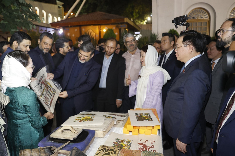 Chủ tịch Quốc hội Vương Đình Huệ và Bộ trưởng Văn hóa và Định hướng Hồi giáo Iran Mohammad Mehdi Esmaili tham quan gian trưng bày, giới thiệu sản phẩm tranh Đông Hồ. (Ảnh: Doãn Tấn/TTXVN)