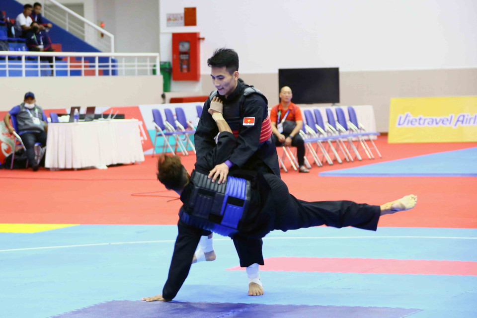 VĐV Vũ Văn Kiên (Việt Nam-giáp đỏ) ghi điểm trước VĐV Muhammad Hazim Bin Mohamad Yusli của Singapore (giáp xanh) ở hạng cân 55kg-60kg. (Ảnh: Quang Quyết/TTXVN)