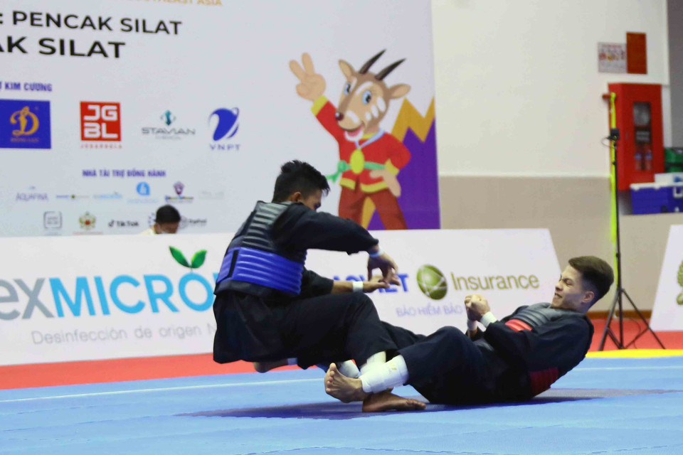 Pha tấn công VĐV Nguyễn Đình Tuấn (Việt Nam-giáp đỏ) trước VĐV Dines Dumaan của Philippines (giáp xanh) ở hạng cân 50kg-55kg. (Ảnh: Quang Quyết/TTXVN)