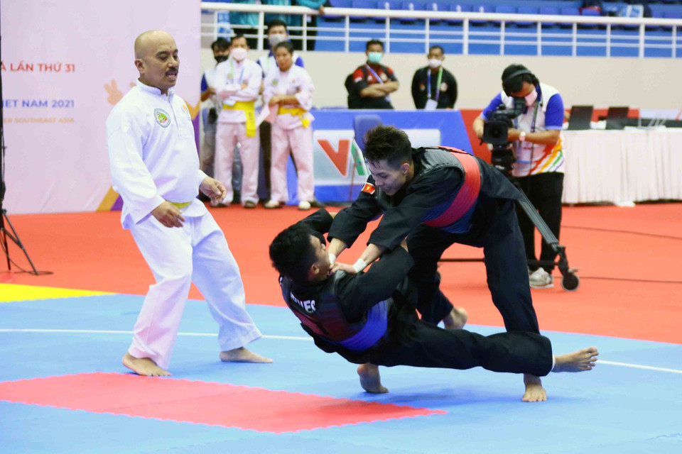 VĐV Nguyễn Đình Tuấn (Việt Nam-giáp đỏ) giành chiến thắng trước VĐV Dines Dumaan của Philippines (giáp xanh) ở hạng cân 50kg-55kg nội dung đối kháng nam (Tanding). (Ảnh: Quang Quyết/TTXVN)