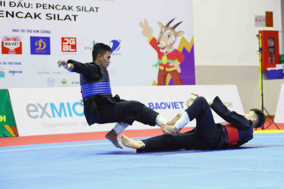 VĐV Nguyễn Đình Tuấn (Việt Nam-giáp đỏ) giành chiến thắng trước VĐV Dines Dumaan của Philippines (giáp xanh) ở hạng cân 50kg-55kg nội dung đối kháng nam (Tanding). (Ảnh: Quang Quyết/TTXVN)