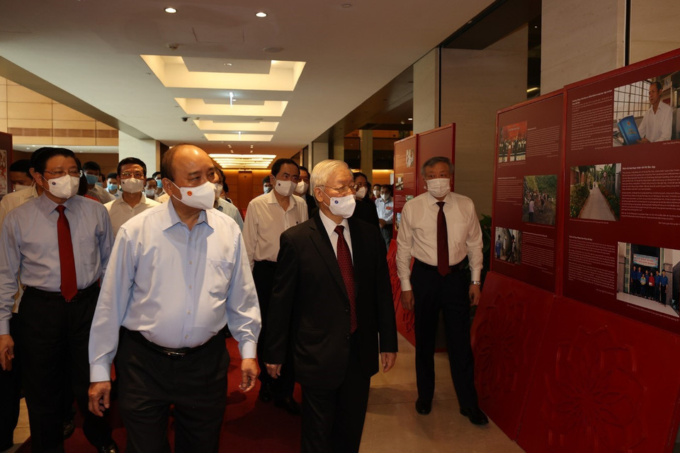 Tổng Bí thư Nguyễn Phú Trọng, Chủ tịch nước Nguyễn Xuân Phúc, Thường trực Ban Bí thư Võ Văn Thưởng và các đại biểu thăm Triển lãm Những tấm gương bình dị mà cao quý trưng bày bên sảnh hội nghị. (Ảnh: Trí Dũng/TTXVN)