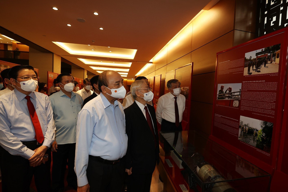 Tổng Bí thư Nguyễn Phú Trọng, Chủ tịch nước Nguyễn Xuân Phúc, Thường trực Ban Bí thư Võ Văn Thưởng và các đại biểu thăm Triển lãm Những tấm gương bình dị mà cao quý trưng bày bên sảnh hội nghị. (Ảnh: Trí Dũng/TTXVN)