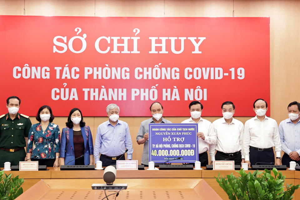 Chủ tịch nước Nguyễn Xuân Phúc trao số tiền hỗ trợ công tác phòng, chống COVID-19 cho thành phố Hà Nội. (Ảnh: Thống Nhất/TTXVN)