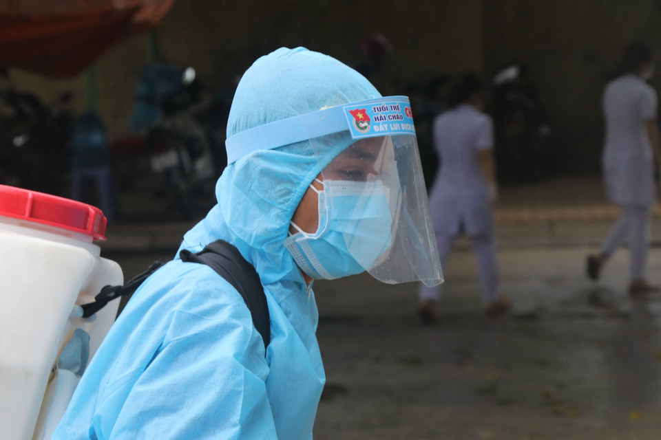 Nhân viên y tế khử trùng các phương tiện ra vào khu vực bệnh viện dã chiến. (Ảnh: Quốc Dũng/TTXVN)