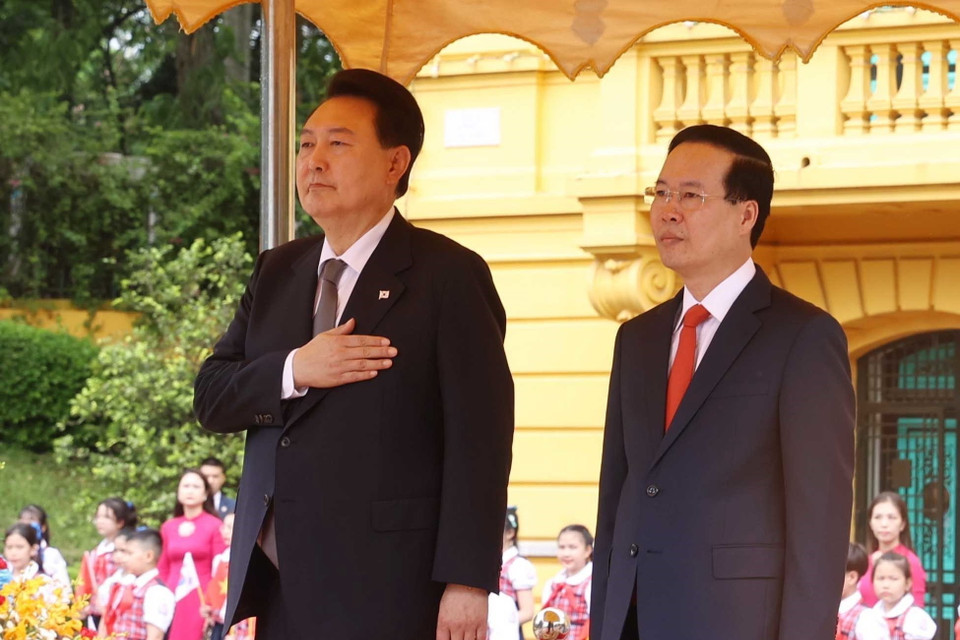Chủ tịch nước Võ Văn Thưởng và Tổng thống Hàn Quốc Yoon Suk Yeol nghe quân nhạc cử Quốc thiều hai nước. (Ảnh: Thống Nhất/TTXVN)