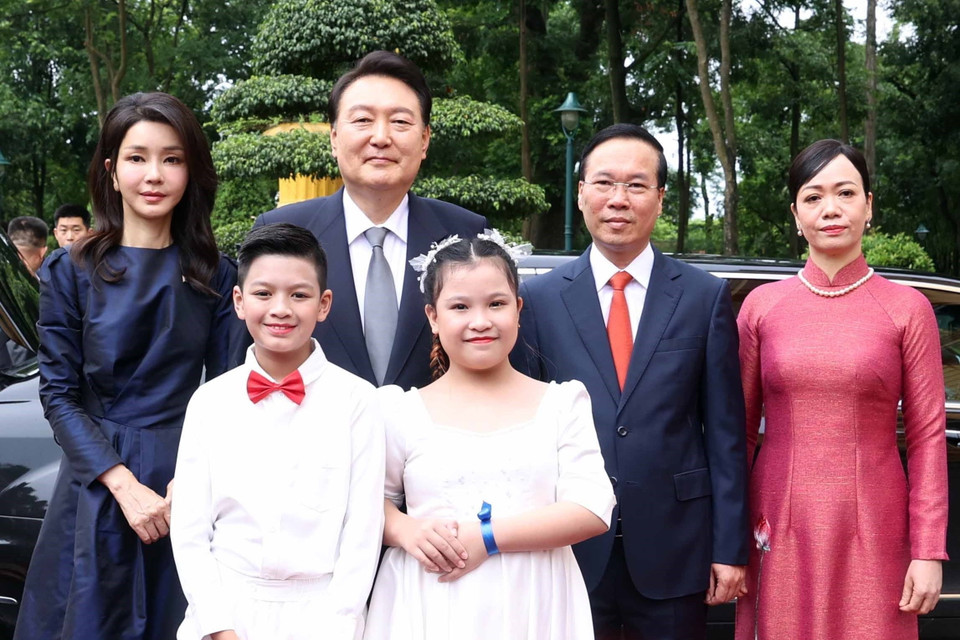 Chủ tịch nước Võ Văn Thưởng và Phu nhân cùng Tổng thống Hàn Quốc Yoon Suk Yeol và Phu nhân với thiếu nhi Thủ đô tại lễ đón. (Ảnh: Thống Nhất/TTXVN)