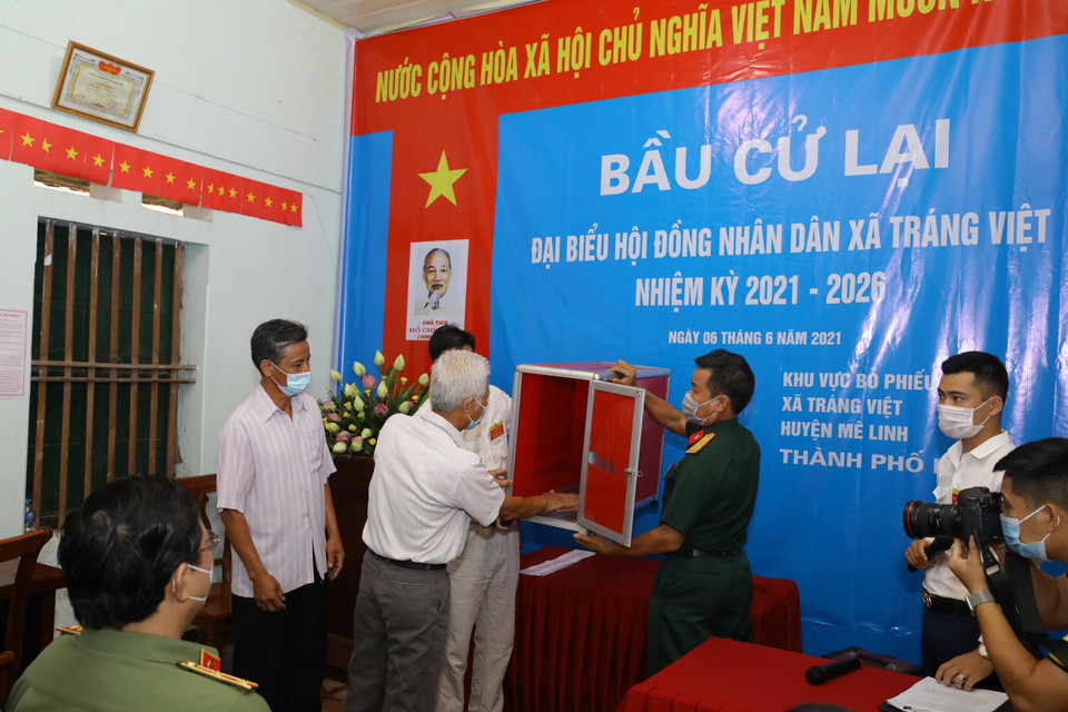 Công tác kiểm tra, niêm phong hòm phiếu tại Khu vực bỏ phiếu số 04, xã Tráng Việt, huyện Mê Linh, Thành phố Hà Nội. (Ảnh: Nguyễn Điệp/TTXVN)