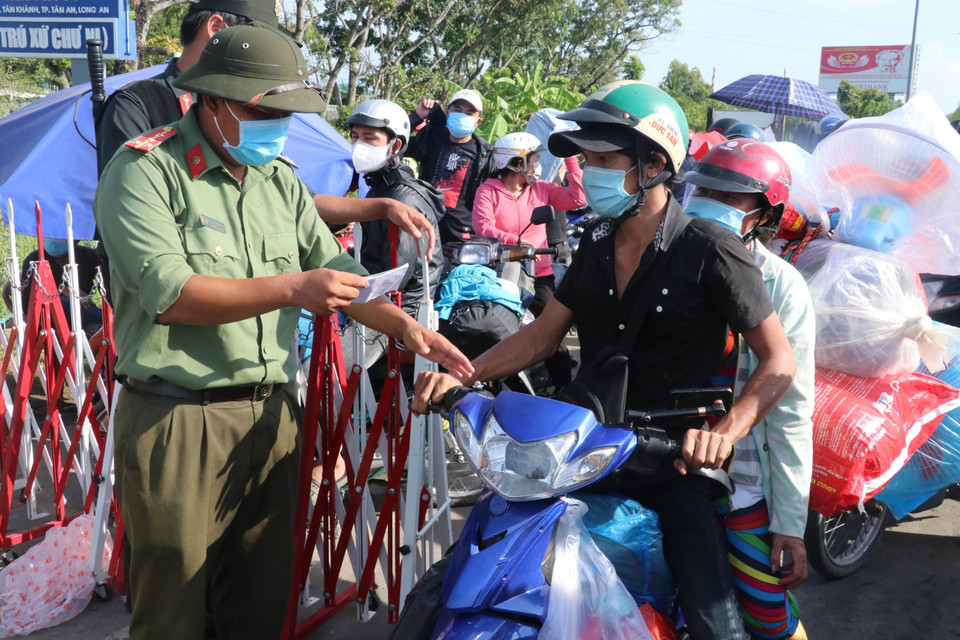 Lực lượng chức năng kiểm tra giấy tờ của người dân khi qua chốt kiểm soát dịch trên Quốc lộ 1. (Ảnh: Bùi Giang/TTXVN)