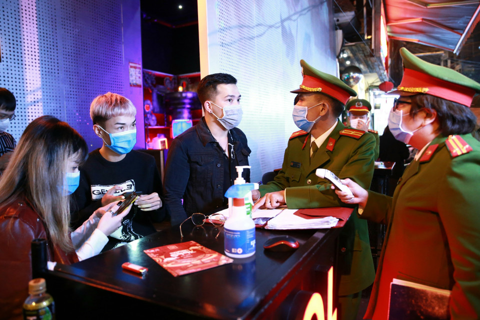 Lực lượng Công an quận Hoàn Kiếm kiểm tra thiết bị đo thân nhiệt tại vũ trường The Bunker, nơi tập trung đông người tại phố Mã Mây, quận Hoàn Kiếm. (Ảnh: Doãn Tấn/TTXVN)