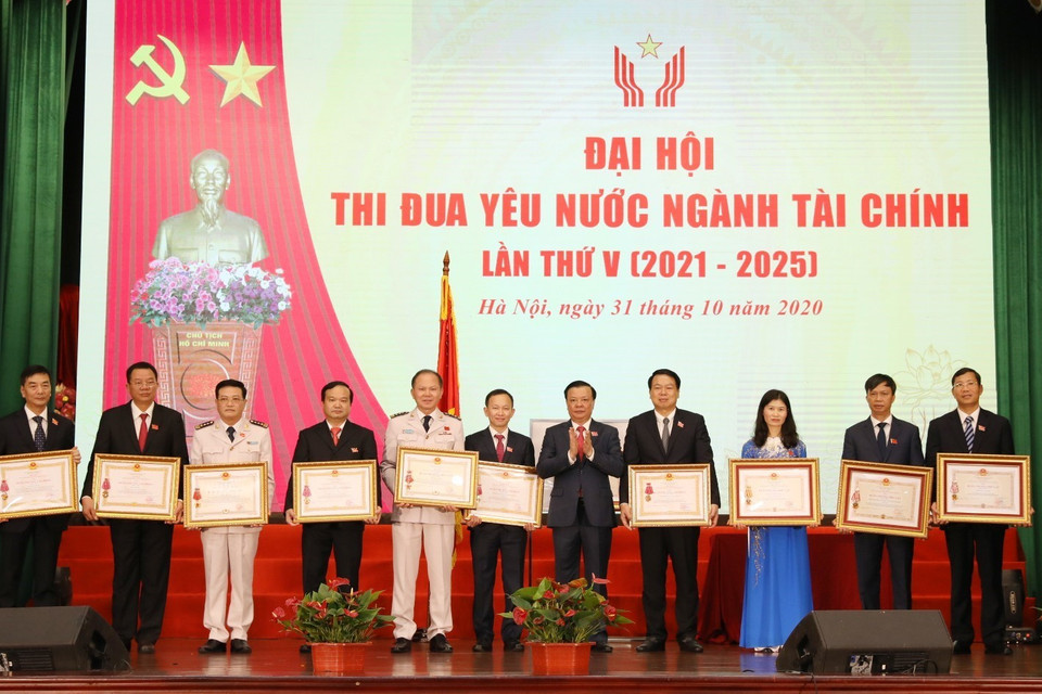 Bộ trưởng Bộ Tài chính Đinh Tiến Dũng trao Huân chương Độc lập các hạng của Chủ tịch nước tặng cá nhân, tập thể. (Ảnh: Phạm Hậu/TTXVN)