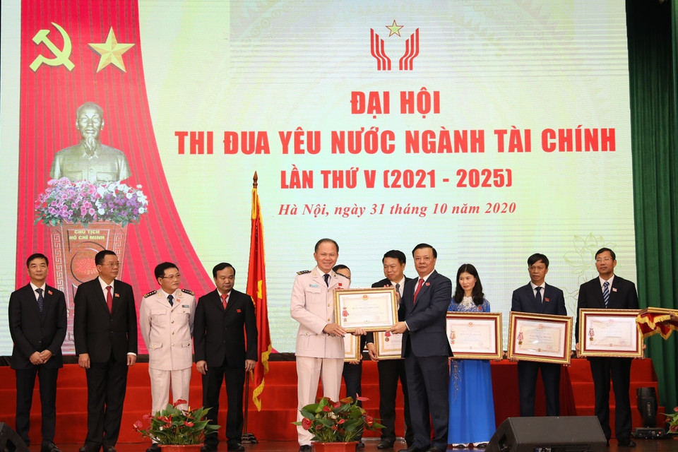 Bộ trưởng Bộ Tài chính Đinh Tiến Dũng trao Huân chương Độc lập các hạng của Chủ tịch nước tặng cá nhân, tập thể. (Ảnh: Phạm Hậu/TTXVN)