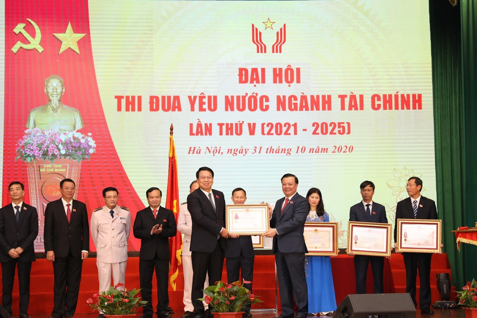 Bộ trưởng Bộ Tài chính Đinh Tiến Dũng trao Huân chương Độc lập các hạng của Chủ tịch nước tặng cá nhân, tập thể. (Ảnh: Phạm Hậu/TTXVN)