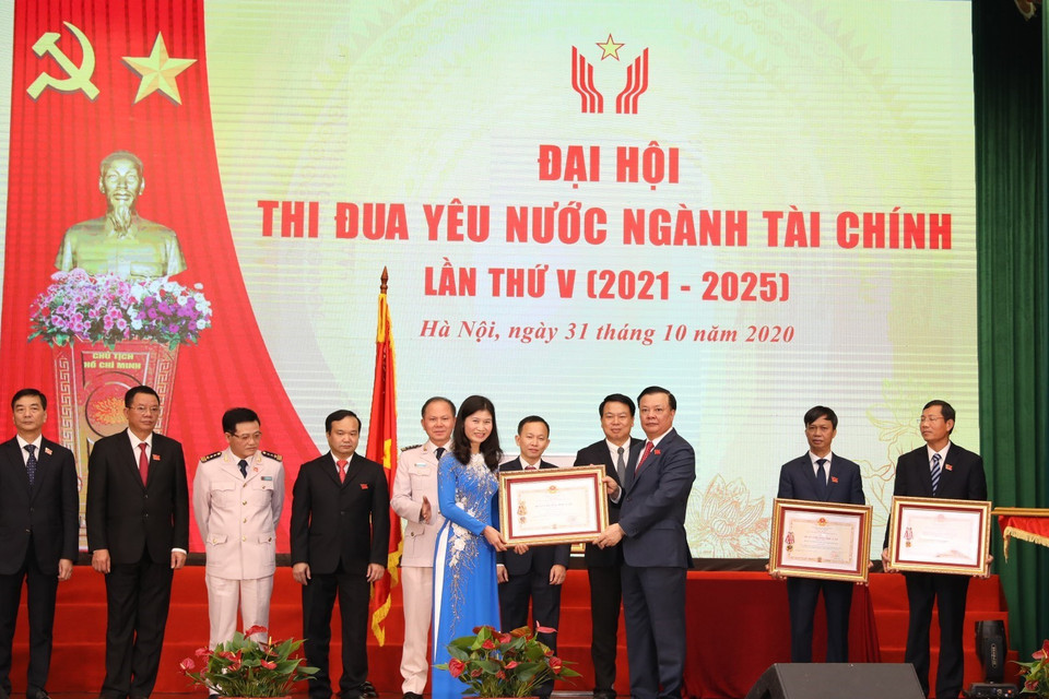 Bộ trưởng Bộ Tài chính Đinh Tiến Dũng trao Huân chương Độc lập các hạng của Chủ tịch nước tặng cá nhân, tập thể. (Ảnh: Phạm Hậu/TTXVN)