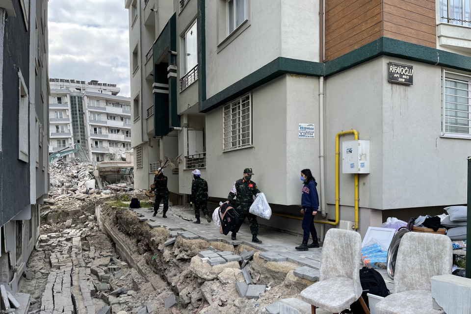 Các chiến sỹ lực lượng cứu hộ, cứu nạn của Quân đội Nhân dân Việt Nam giúp đỡ người dân di chuyển đồ khỏi nơi đổ nát. (Ảnh: TTXVN)