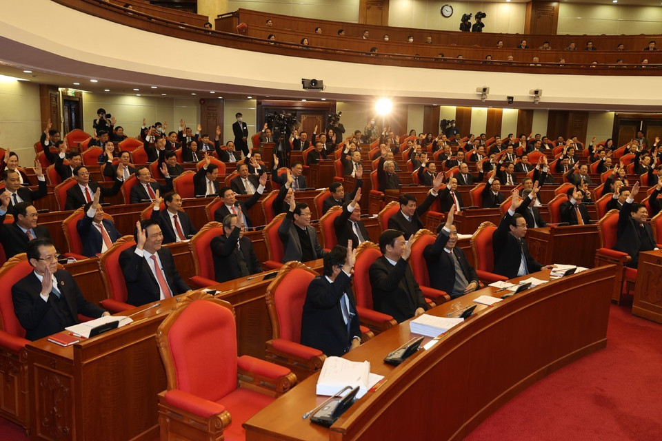 Các vị lãnh đạo Đảng, Nhà nước và các đại biểu biểu quyết thông qua Nghị quyết Hội nghị Trung ương lần thứ mười bốn. (Ảnh: Trí Dũng/TTXVN)