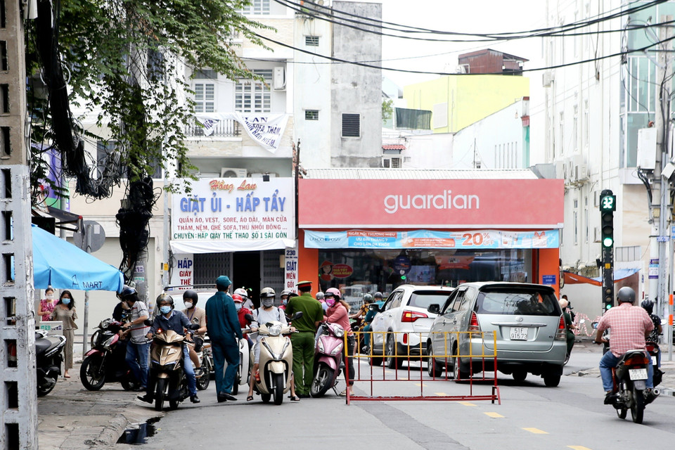 Lực lượng trực chốt kiểm soát trên đường Huỳnh Văn Bánh, quận Phú Nhuận làm việc khá vất vả trong sáng 13/8. (Ảnh: Thành Chung/TTXVN)