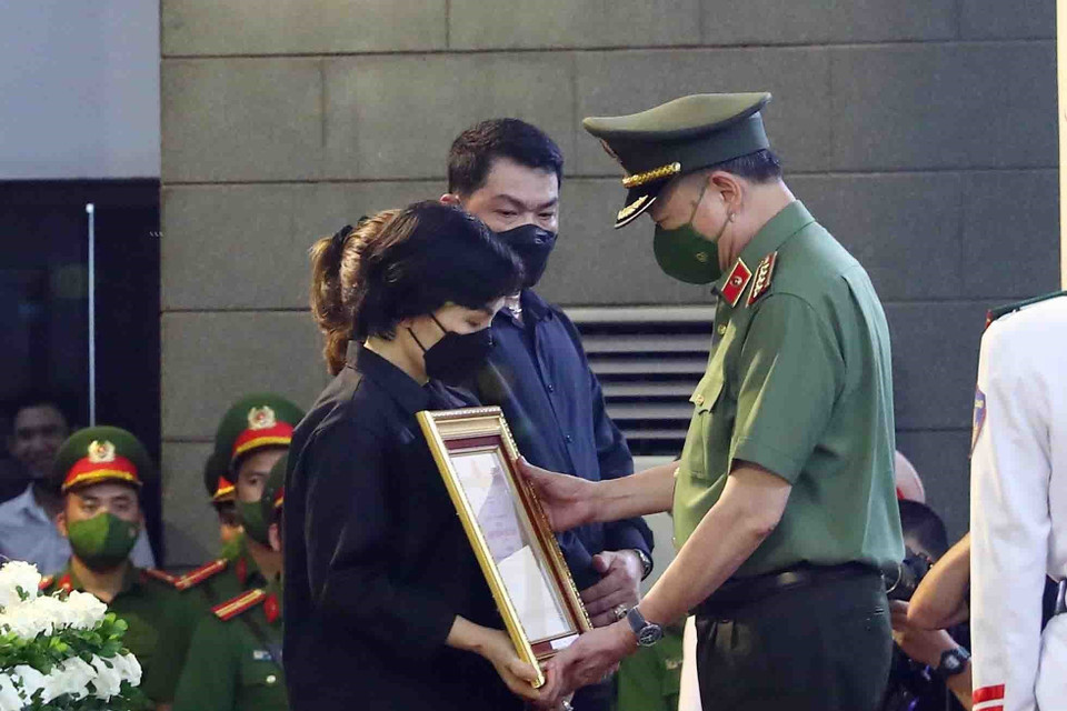 Đại tướng Tô Lâm, Ủy viên Bộ Chính trị, Bộ trưởng Bộ Công an trao Huân chương Chiến công hạng Nhất cho gia đình Hạ sỹ Nguyễn Đình Phúc (Chiến sỹ nghĩa vụ, Đội Cảnh sát phòng cháy chữa cháy và cứu nạn cứu hộ, Công an quận Cầu Giấy). (Ảnh: Phạm Kiên/TTXVN)