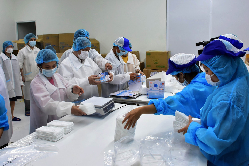 Công ty TNHH Kim Sora (Thừa Thiên-Huế) tăng ca sản xuất để tăng số lượng khẩu trang, kịp thời phân phối cho thị trường phục vụ phòng, chống dịch COVID-19. (Ảnh: Hồ Cầu/TTXVN)