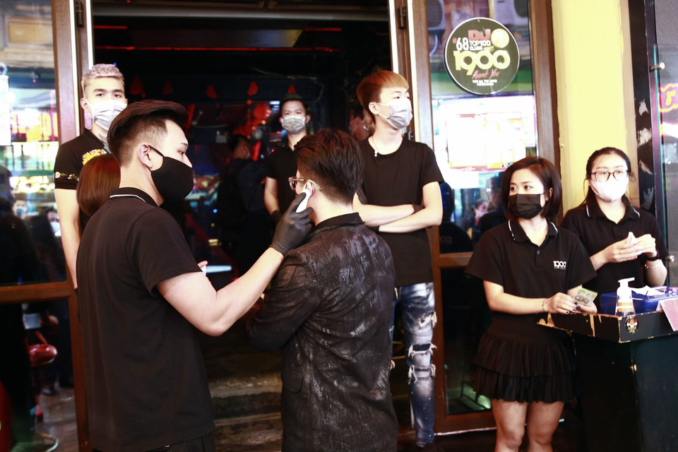 Khách hàng vào các quán bar, karaoke phải đo thân nhiệt. (Ảnh: Doãn Tấn/TTXVN)