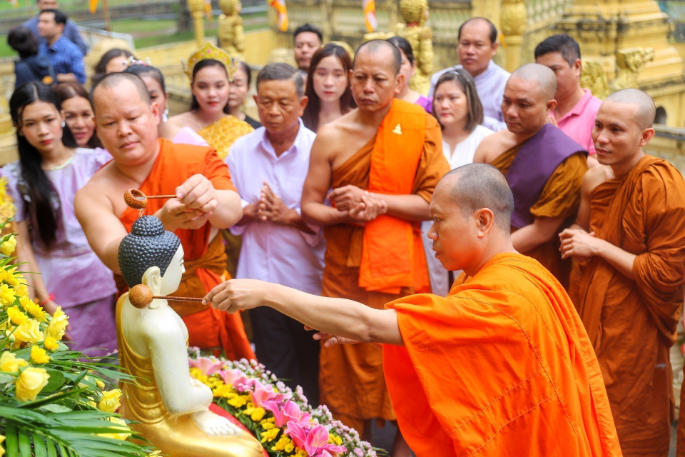 Nghi thức tắm Phật bằng nước ướp hương, gột rửa những điều không may mắn trong năm cũ để sang năm mới mọi sự được như ý. (Ảnh: Tuấn Đức/TTXVN)