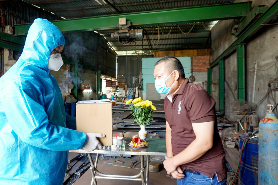 Cán bộ, chiến sỹ Ban Chỉ huy quân sự quận Bình Chánh bàn giao tro cốt người mất vì COVID-19 cho nhân thân. (Ảnh: Xuân Khu/TTXVN)