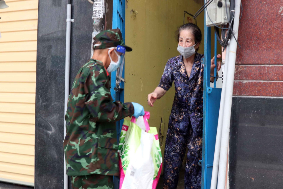 Lực lượng quân đội tăng cường trao lương thực thực phẩm cho người dân Thành phố. (Ảnh: Xuân Khu/TTXVN)