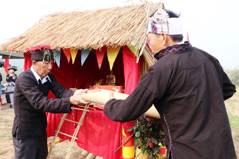 Thầy cúng lựa chọn 15 chàng trai khỏe mạnh nhất bản cầm ống nước để thực hiện nghi lễ rửa tượng Phật nhằm cầu mong những điều mới mẻ trong năm mới. (Ảnh: Đinh Thùy/TTXVN)