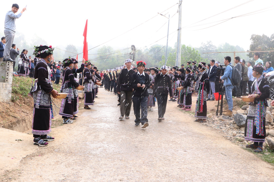 Các gia đình trong bản đứng hai bên đường để té nước vào đoàn rước nước dâng lên cúng tượng Phật với mong muốn cho gia đình năm mới sẽ được may mắn, sức khỏe, làm ăn phát đạt. (Ảnh: Đinh Thùy/TTXVN)