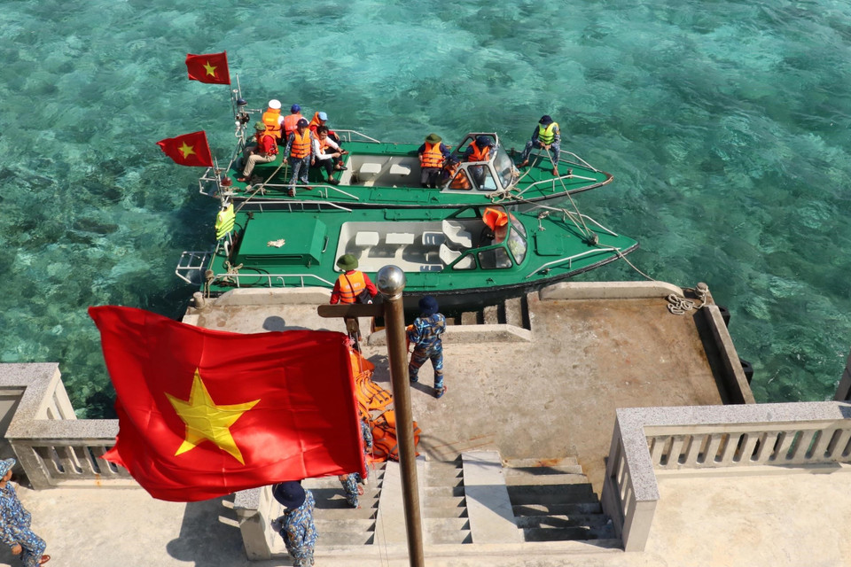 Cờ Tổ quốc tung bay phấp phới khi hai xuồng của tàu Trường Sa 571 cập mạn trên đảo Cô Lin. (Ảnh: Sỹ Tuyên/TTXVN)