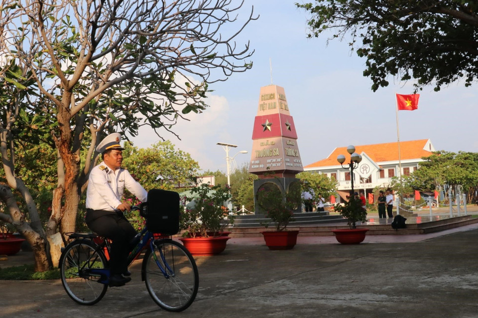 Đại tá Lê Đình Hải, Phó Lữ đoàn trưởng - Lữ đoàn 146 (vùng 4 Hải quân) đạp xe ngang qua cột mốc thị trấn Trường Sa (huyện Trường Sa, tỉnh Khánh Hoà). (Ảnh: Sỹ Tuyên/TTXVN)