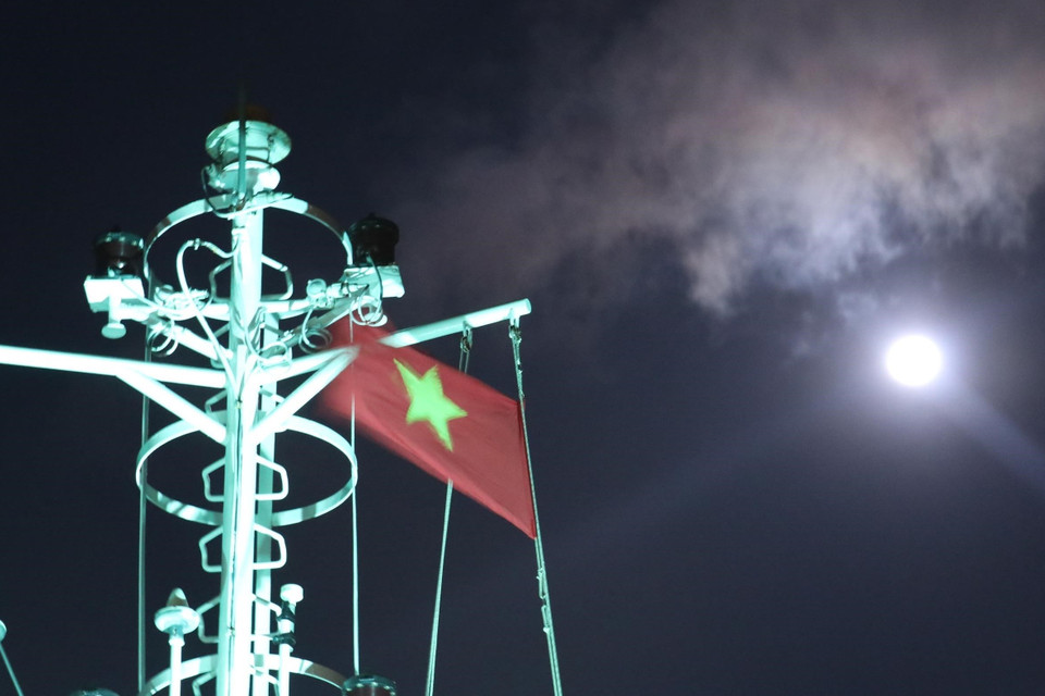 Cờ Tổ quốc trên nóc tàu Trường Sa 571 tung bay phấp phới dưới ánh trăng khi tàu đi trên vùng biển gần đảo Song Tử Tây – quần đảo Trường Sa (huyện Trường Sa, tỉnh Khánh Hoà). (Ảnh: Sỹ Tuyên/TTXVN)