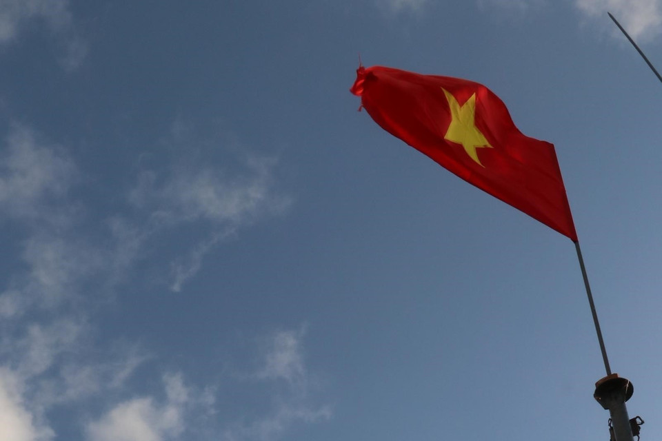 Trung sỹ Đặng Trọng Hiếu - Đảo Thuyền Chài C đứng gác dưới cột cờ Tổ quốc trên nóc đảo. (Ảnh: Sỹ Tuyên/TTXVN)